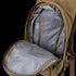 The Hydration Backpack 8L by Condor is open, displaying its brown exterior and grey patterned interior, revealing the main compartment and part of the zipper.